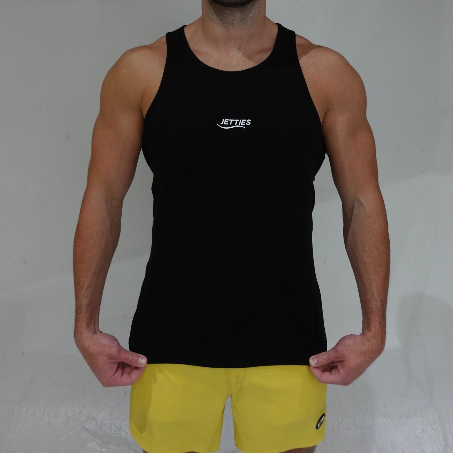JETTIES Ascend Tank Top in black, lightweight athletic tank with logo graphic, front view