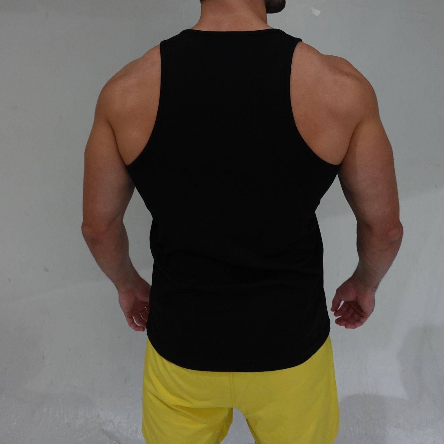 JETTIES Ascend Tank Top in black, lightweight athletic tank with logo graphic, back view