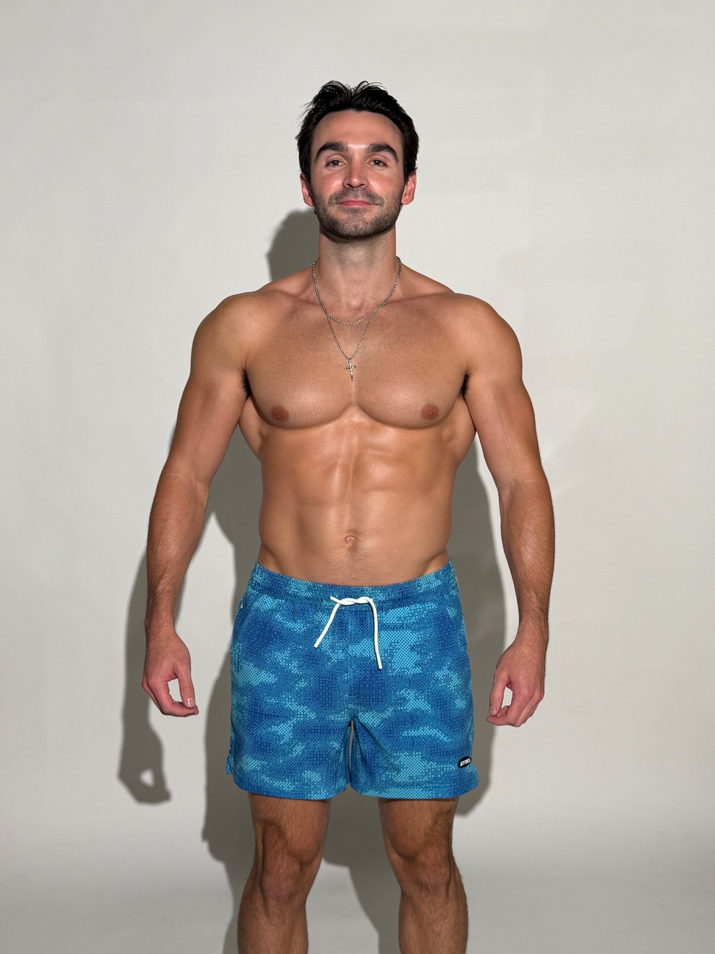 Model wearing the Thermal, multiple blues digital pixel camo mens bathing suit