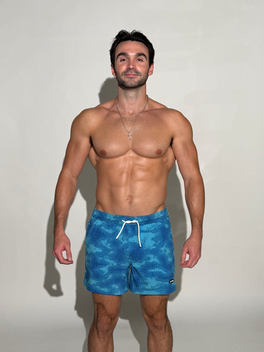 Model wearing the Thermal, multiple blues digital pixel camo mens bathing suit
