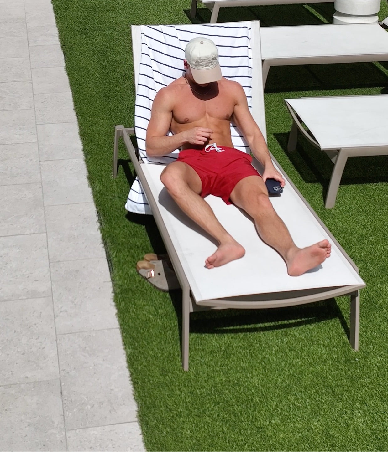 Model in TIMELESS RED PLUNGE SHORT lounging and tanning