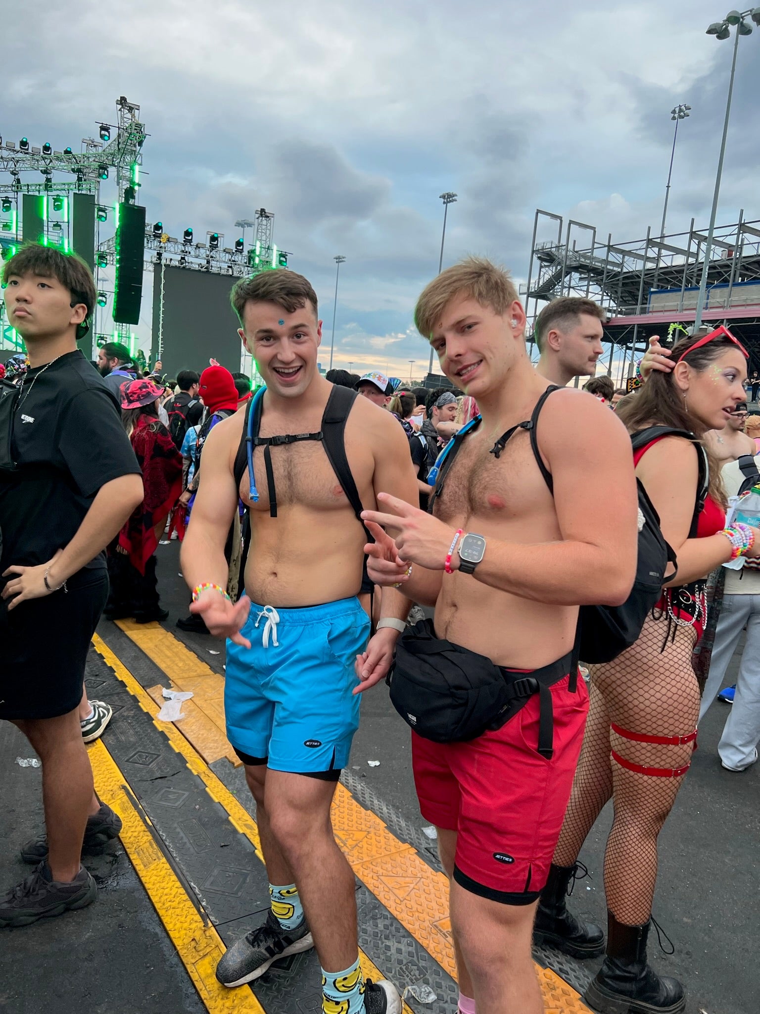 Two men in JETTIES PLUNGE SHORT swimwear/athletic shorts at a music festival comfortable and having fun