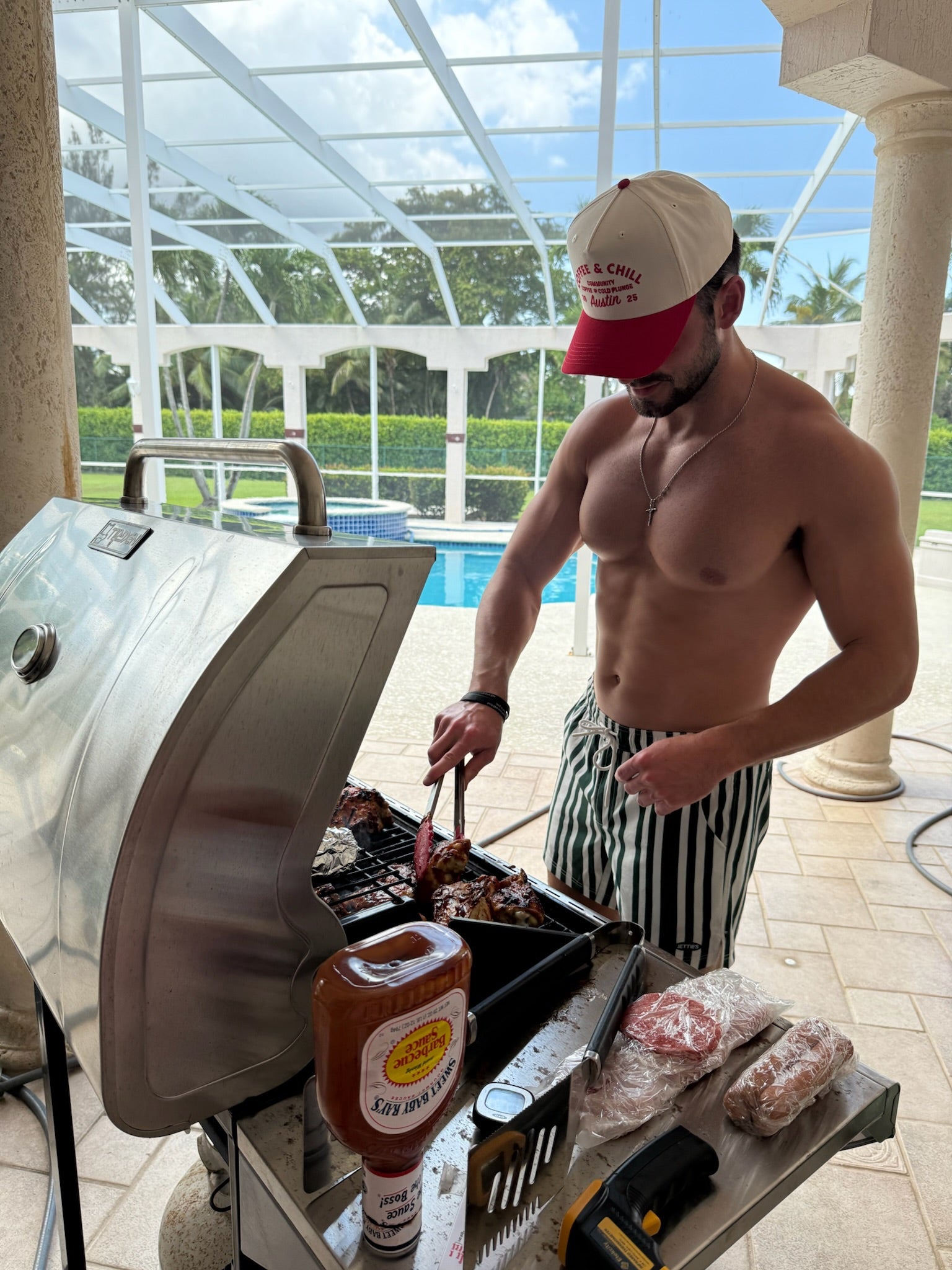 Model grilling outside in JETTIES CODE GREEN PLUNGE SHORT bathing suit