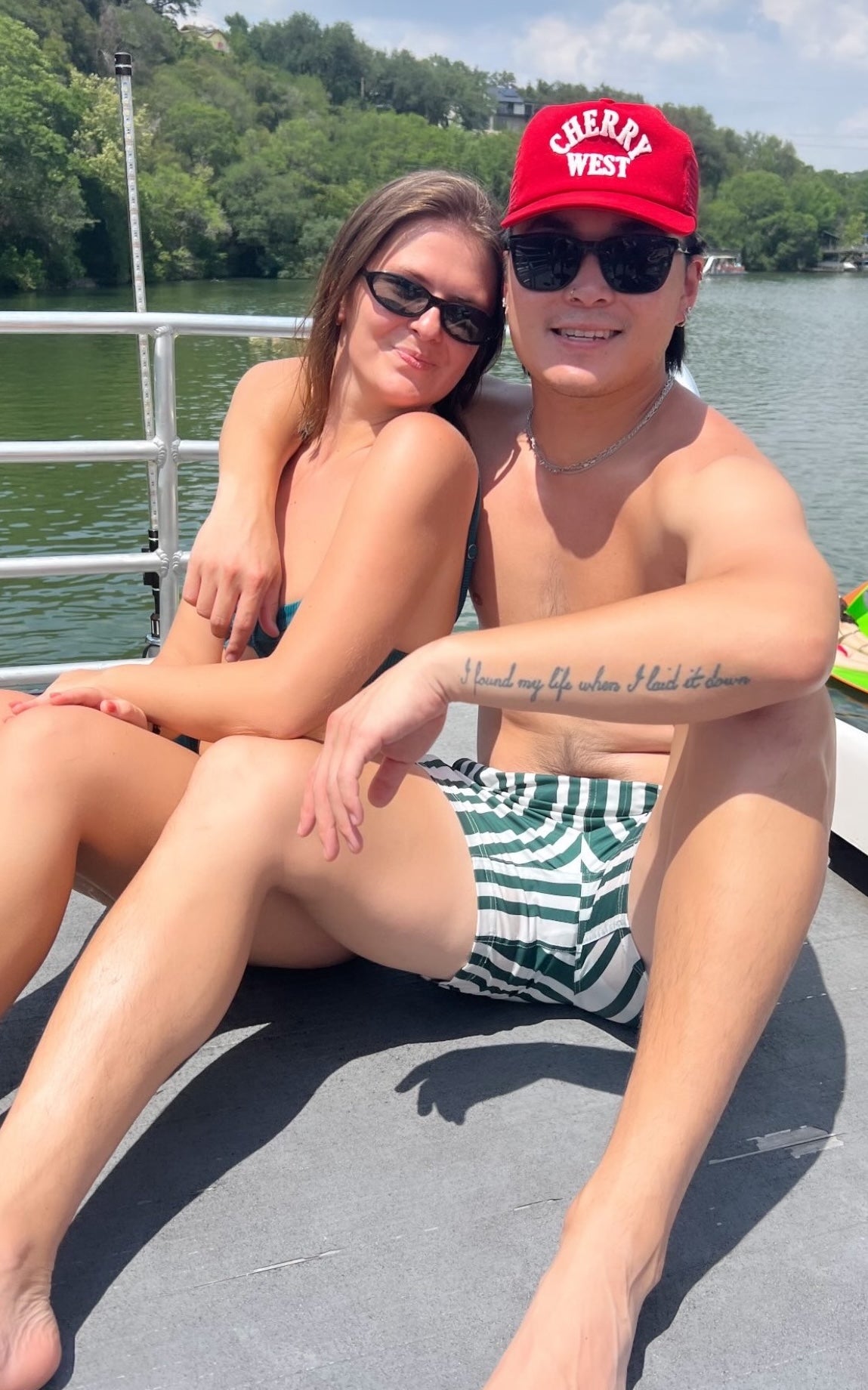 Couple on a boat, man wearing JETTIES CODE GREEN PLUNGE SHORT swimwear