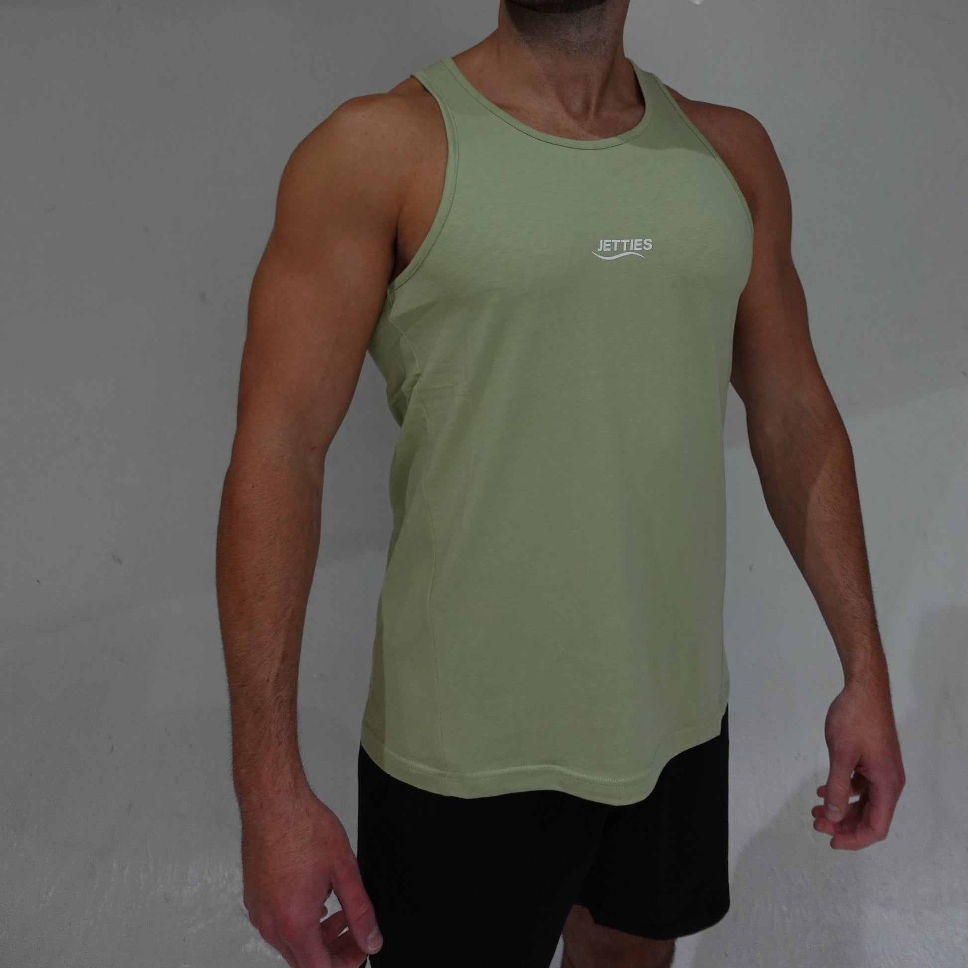 JETTIES Ascend Tank Top in matcha green, lightweight athletic tank with logo graphic, side view